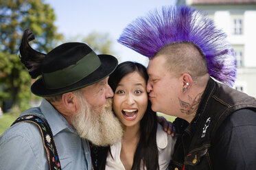 Germany, Bavaria, Upper Bavaria, Two men kissing Asian woman on cheek, portrait - WESTF09551