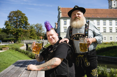 Germany, Bavaria, Upper Bavaria, Man with mohawk hairstyle and Bavarian man in beergarden - WESTF09546