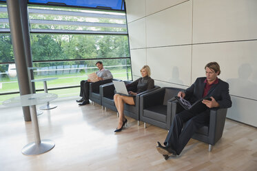 Germany, business people sitting in lounge, working - WESTF10340