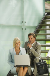 Deutschland, zwei Geschäftsleute auf einer Treppe sitzend, Frau mit Laptop - WESTF10245
