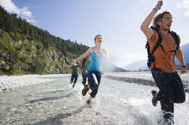 Deutschland, Bayern, Tölzer Land, Junge Freunde laufen durch den Fluss - WESTF09914