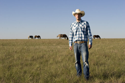 USA, Texas, Dallas, Cowboy standing on pasture - PK00250