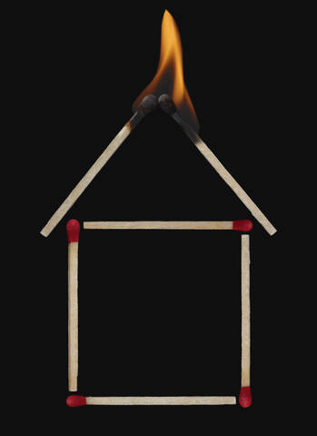 Burning roof of matchstick house, close-up stock photo