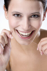 Junge Frau bei der Verwendung von Zahnseide, Nahaufnahme - MAEF01298