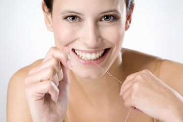 Junge Frau bei der Verwendung von Zahnseide, Nahaufnahme - MAEF01297