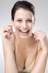 Young woman flossing her teeth, close up - MAEF01294