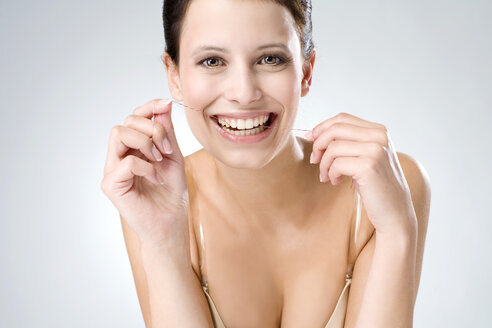 Junge Frau bei der Verwendung von Zahnseide, Nahaufnahme - MAEF01293