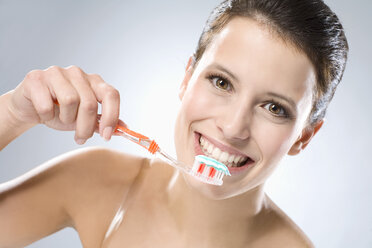 Young woman brushing her teeth, smiling, close up - MAEF01289