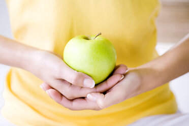 Woman holding an apple, close up - MAEF01215