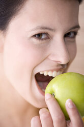 Junge Frau hält einen Apfel, lächelnd, Porträt - MAEF01214