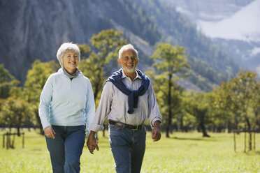 Austria, Karwendel, Ahornboden, Senior couple walking across meadow, hand in hand - WESTF10541