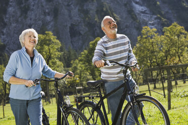 Austria, Karwendel, Ahornboden, Senior couple pushing bikes - WESTF10534