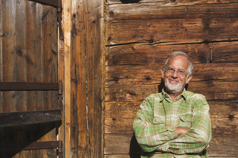 Austria, Senior man, arms crossed, smiling, portrait stock photo