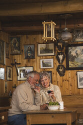 Senior couple sitting at table in Log Cabin - WESTF10420