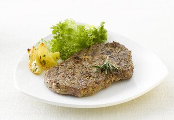 Steak with potatoes, pepper, rosemary and lettuce, close-up - KSWF00210