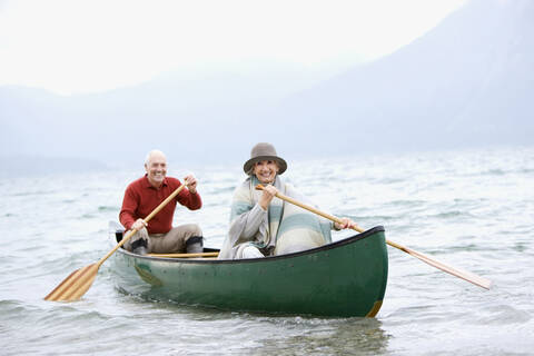 Deutschland, Bayern, Walchensee, Seniorenpaar rudert Boot auf See, lizenzfreies Stockfoto