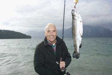 Germany, Bavaria, Walchensee, Senior man fishing in lake - WESTF10206