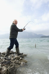Deutschland, Bayern, Walchensee, Älterer Mann beim Fischen im See - WESTF10202