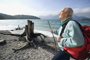 Germany, Bavaria, Walchensee, Senior man taking a break on lakeshore - WESTF10187