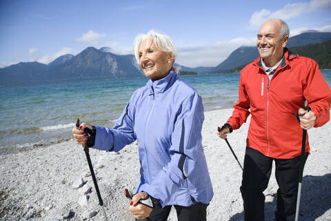 Germany, Bavaria, Walchensee, Senior couple, Nordic Walking on lakeshore stock photo