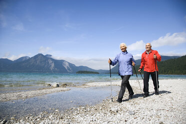Germany, Bavaria, Walchensee, Senior couple, Nordic Walking on lakeshore - WESTF10178