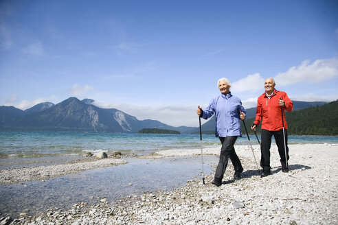 Deutschland, Bayern, Walchensee, Seniorenpaar, Nordic Walking am Seeufer - WESTF10178