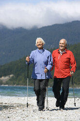 Germany, Bavaria, Walchensee, Senior couple, Nordic Walking on lakeshore - WESTF10176