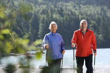 Germany, Bavaria, Walchensee, Senior couple, Nordic Walking on lakeshore - WESTF10174