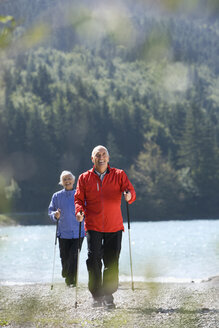 Deutschland, Bayern, Walchensee, Seniorenpaar, Nordic Walking am Seeufer - WESTF10173