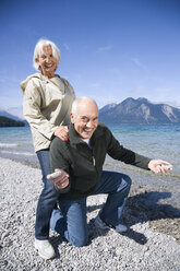 Germany, Bavaria, Walchenseel ,Senior couple fooling about on lakeshore - WESTF10152