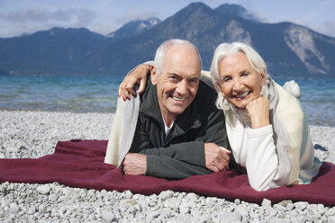 Germany, Bavaria, Walchensee, Senior couple relaxing on lakeshore - WESTF10148