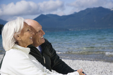 Germany, Bavaria, Walchensee, Senior couple relaxing on lakeshore - WESTF10137