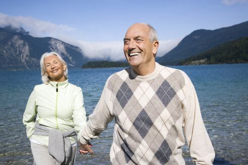 Germany, Bavaria, Walchensee, Senior couple walking hand in hand - WESTF10128