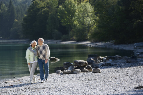 Germany, Bavaria, Walchensee, Senior couple walking across lakeshore - WESTF10113