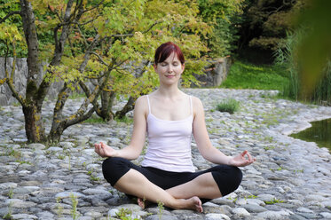 Germany, Bavaria, Munich, Young woman exercising yoga, eyes closed - NHF00975