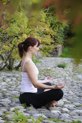 Germany, Bavaria, Munich, Young woman exercising yoga - NHF00974