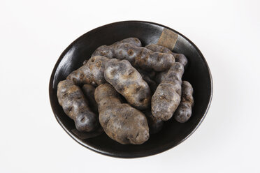 Truffle de Chine blue-violet potatoes in bowl, elevated view - KSWF00228