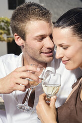 Young couple flirting, holding wine glasses, close-up - ABF00485