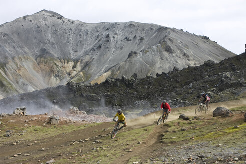 Iceland, Men mountain biking in hilly landscape - FFF00967