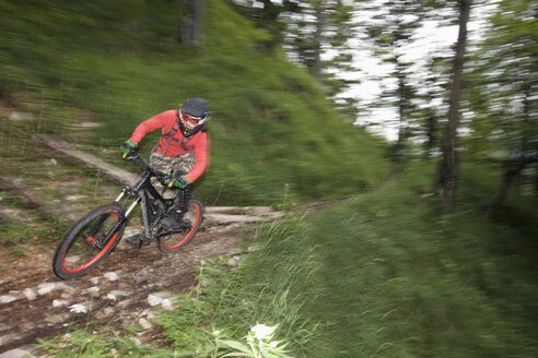 Deutschland, Bayern, Chiemgau, Junger Mann beim Mountainbiken mit hoher Geschwindigkeit - FFF00945