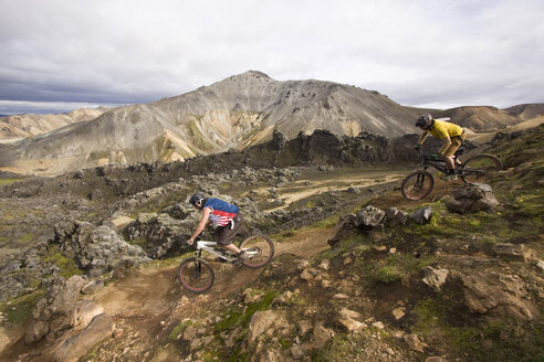 Iceland, Men mountain biking in hilly landscape - FF00995