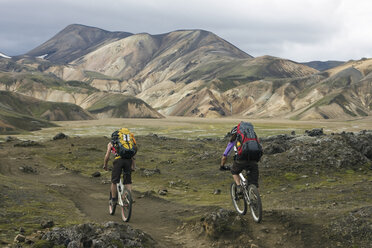 Island, Männer beim Mountainbiking in hügeliger Landschaft - FF00993