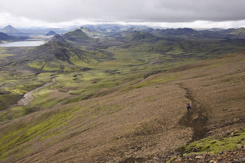 Island, Zwei Männer beim Mountainbiking in hügeliger Landschaft, lizenzfreies Stockfoto