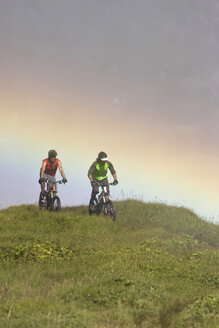 Iceland, Two Men mountain biking in hilly landscape - FF00988