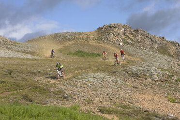 Island, Männer beim Mountainbiking in hügeliger Landschaft - FF00982