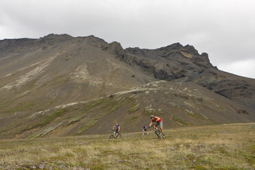 Island, Männer beim Mountainbiking in hügeliger Landschaft - FF00974