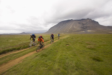 Island, Männer beim Mountainbiking in hügeliger Landschaft - FF00972