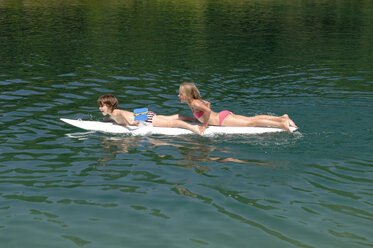 Junge und Mädchen (6-7) auf einem Surfbrett auf dem Wasser - CRF01659