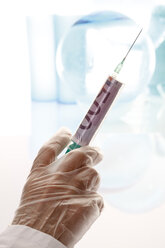 Person holding syringe with 500 Euro note, close-up - 09873CS-U