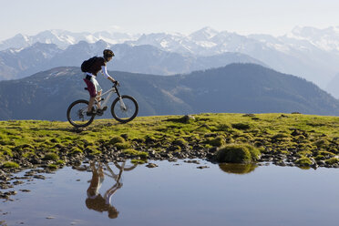 Austria, Salzburger Land, Zell am See, Woman mountain biking - FFF01025